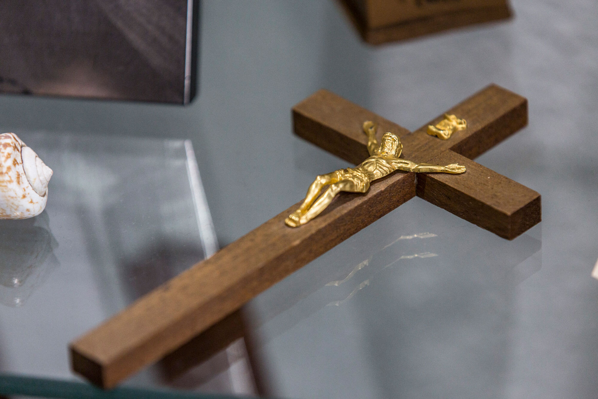 Holzkreuz mit Jesusfigur auf einem Glastisch